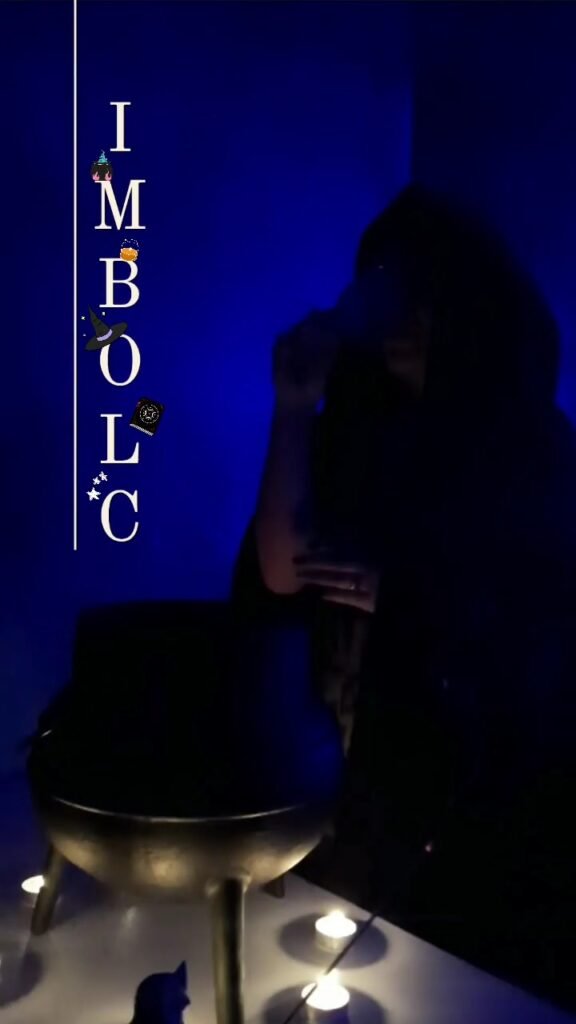 Mica Mihaylova em ambiente escuro e azul, com caldeirão, velas acesas e a palavra IMBOLC na vertical com símbolos místicos